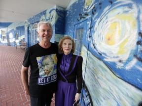 Lubomir Jastrzebski and Nancy Memhauseer stand by a section of a mural at their home in Wednesday, July 18, 2018, in Mount Dora, Fla. The Orlando Sentinel reports the Mount Dora City Council unanimously agreed Tuesday, July 17, 2018, that the couple can keep the mural, and the city must pay them $15,000 and remove a property lien to end the nearly yearlong code enforcement case. The dispute began when the couple painted an exterior wall as a way to calm their son, who is autistic and loves van Gogh's work.