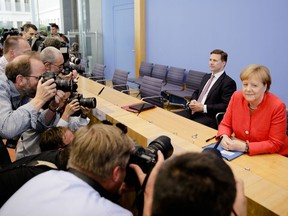 German Chancellor Angela Merkel is surrounded by photographers at the beginning of her annual summer press conference at the Bundespressekonferenz in Berlin, Germany, Friday, July 20, 2018.