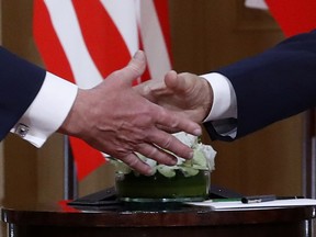 U.S. President Donald Trump, left, and Russian President Vladimir Putin shake hand at the beginning of a meeting at the Presidential Palace in Helsinki, Finland, Monday, July 16, 2018.