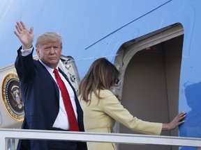 U.S. President Donald Trump waves when boarding Air Force One as he leaves with his wife Melania, right, from the airport in Helsinki, Finland, Monday, July 16, 2018, after the meeting with Russian President Vladimir Putin in the Finnish capital.