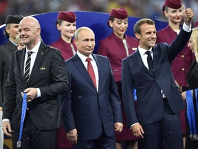 FIFA President Gianni Infantino, Russian President Vladimir Putin and French President Emmanuel Macron, from left, wait on the podium after the final match between France and Croatia at the 2018 soccer World Cup in the Luzhniki Stadium in Moscow, Russia, Sunday, July 15, 2018.