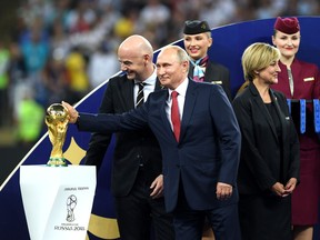 Russian President Vladimir Putin touches the World Cup trophy in Moscow on July 15.