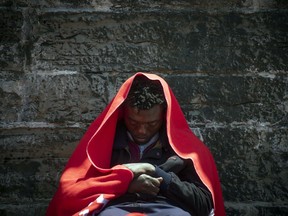 In this photo taken on Tuesday, July 24, 2018, a migrant rests at the port of Tarifa, southern Spain, after being rescued by Spain's Maritime Rescue Service in the Strait of Gibraltar. Spain's Maritime Rescue Service says that nearly 900 people have been rescued from waters south of the Iberian Peninsula over the past two days, as an increase in arrivals increases pressure on the country's infrastructure to deal with migration.
