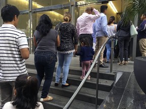 In this June 28, 2018, photo, people line up outside the building that houses the immigration courts in Los Angeles. In recent weeks, immigration judges have been thrust into the center of the heated political controversy over how the Trump administration is handling the cases of mostly Central American immigrants caught on southwest border.