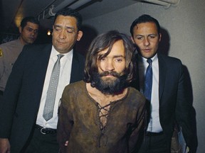 FILE - In this 1969 file photo, Charles Manson is escorted to his arraignment on conspiracy-murder charges in connection with the Sharon Tate murder case. A Los Angeles judge has eliminated two purported sons of Charles Manson from the battle over his estate. Judge Clifford Klein on Friday, July 13, 2018 narrowed the case down to a man who says he's the cult leader's grandson and a memorabilia collector who was pen pals with Manson. (AP Photo, File)