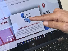 FILE - In this June 18, 2018, file photo, venture capitalist Tim Draper points to a computer screen at his offices in San Mateo, Calif., showing that an initiative to split California into three states qualified for the ballot. The California Supreme Court has blocked a measure that would divide the state in three from appearing on the November ballot. The justices on Wednesday, July 18, 2018, ordered the secretary of state not to put the initiative before voters, saying significant questions have been raised about its validity.