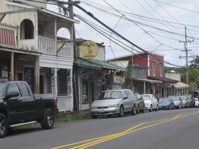 FILE - This Sept. 8, 2014 file photo shows downtown Pahoa, Hawaii. The small, rural town of Pahoa is the gateway to the eruption pouring rivers of lava out of Hawaii's Kilauea volcano. Historic wooden buildings lining its main street are just a few miles from where a cinder cone shooting lava into the sky has popped up in people's yards. Tourism to parts of the island has plummeted since the volcano began erupting in a residential neighborhood and burning down homes in May.