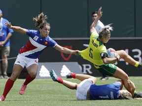 Australia's Emma Tonegato (5) is tackled by France's Marjorie Mayans (1) as a teammate closes in during a Women's Rugby Sevens World Cup semifinal in San Francisco, Saturday, July 21, 2018.