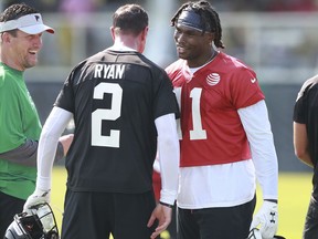 Atlanta Falcons wide receiver Julio Jones, right, gives Matt Ryan a chest bump with quarterbacks coach Greg Knapp looking on the first day of the NFL football team's training camp, Friday, July 27, 2018, in Flowery Branch, Ga.