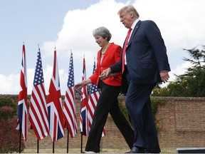 President Donald Trump and British Prime Minister Theresa May hold hands at the conclusion of their joint news conference at Chequers, in Buckinghamshire, England, Friday, July 13, 2018.