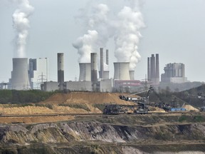 In this April 3, 2014 file photo giant machines dig for brown coal at the open-cast mining Garzweiler in front of a power plant near the city of Grevenbroich in western Germany.