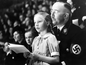 In this March 6, 1938 file photo Chief of the German Police and Minister of the Interior Heinrich Himmler, with his daughter Gudrun on his lap, watch an indoor sports display in Berlin.