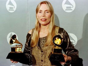 Joni Mitchell smiles as she holds two Grammy Awards at 38th Annual Grammy Awards 28 February in Los Angeles. Mitchell won Grammys for Best Pop Album for "Turbulent Indigo."