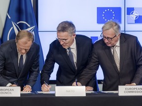 European Council President Donald Tusk, left, European Commission President Jean-Claude Juncker, right, and NATO Secretary General Jens Stoltenberg sign the second EU NATO Joint Declaration, in Brussels on Tuesday, July 10, 2018.  The Joint Declaration between NATO and the European Union commits the partners on cooperation and security.
