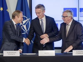 European Council President Donald Tusk, left, European Commission President Jean-Claude Juncker, right, and NATO Secretary General Jens Stoltenberg shake hands after the signature of the second EU NATO Joint Declaration, in Brussels on Tuesday, July 10, 2018.  The Joint Declaration between NATO and the European Union commits the partners on cooperation and security.