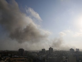 Smoke and fire from an Israeli strike rise over Gaza City, Saturday, July 14, 2018.  The Israeli military carried out its largest daytime airstrike campaign in Gaza since the 2014 war as Hamas militants fired dozens of rockets into Israel, threatening to spark a wider conflagration after weeks of tensions along the volatile border.