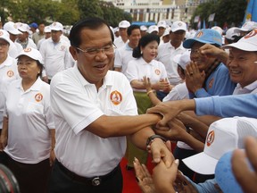 Cambodian Prime Minister Hun Sen, center, greets supporters upon arrival for his Cambodian People's Party's campaign in Phnom Penh, Cambodia, Saturday, July 7, 2018. The official campaigning period for July 29 general election began with Hun Sen's ruling party virtually assured victory after the only credible opposition party was dissolved last year.