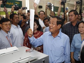 Cambodian Prime Minister Hun Se looks his ballot at a polling station in Takhmua, Kandal province, southeast of Phnom Penh, Cambodia, Sunday, July 29, 2018. With the main opposition silenced, Cambodians were voting in an election Sunday virtually certain to return to office Prime Minister Hun Sen and his party who have been in power for more than three decades.