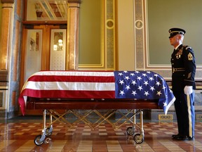 An Honor Guard member stands next to the casket of former Iowa Gov. Robert Ray before before a ceremony, Thursday, July 12, 2018, at the Statehouse in Des Moines, Iowa.