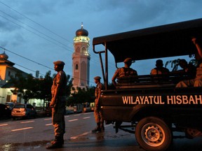 In this Dec. 31, 2013 file photo, Sharia police officers stand guard at a check point set up to prevent people from celebrating New Year's eve in Banda Aceh, Aceh Province, Indonesia. An Indonesian teen has been jailed for six months for an abortion after being raped repeatedly by her brother