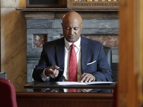 Indiana Attorney General Curtis Hill returns to his desk following a news conference at the Statehouse in Indianapolis, Monday, July 9, 2018. Hill is rejecting calls to resign, saying his name "has been dragged through the gutter" amid allegations that he inappropriately touched a lawmaker and several other women. The Republican said during the news conference that he stands "falsely and publicly accused of abhorrent behavior."