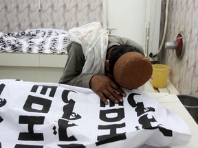 A Pakistani mourns over a dead body of his family member who is killed in a bomb attack, at a mortuary in Quetta, Pakistan, Friday, July 13, 2018. Underscoring the security threat, two bombs exploded Friday killing many people in the latest election related violence to hit Pakistan. The first bomb that killed four people exploded in northwest Pakistan near the election rally of a senior politician from an Islamist party who is running for parliament from the northwestern town of Bannu.