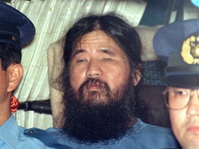 In this Sept. 25, 1995, file photo, cult leader Shoko Asahara sits in a police van following an interrogation in Tokyo.