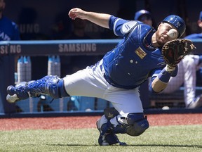 Toronto Blue Jays catcher Russell Martin bobbles but makes the catch on foul ball off the bat of New York Yankees Didi Gregorius in Toronto on Sunday, July 8, 2018. (THE CANADIAN PRESS/Fred Thornhill)