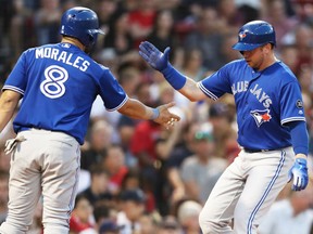 Toronto Blue Jays' Justin Smoak, right, is congratulated by Kendrys Morales after scoring a run during MLB action Friday night at Boston's Fenway Park. Smoak had a pair of homers in powering the Jays to a 13-7 victory, snapping the Red Sox winning streak at 10 games.
