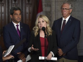 Conservative MP Michelle Rempel stands with MPs Pierre Paul-Hus and Larry Maguire as she speaks to reporters ahead of an emergency meeting of the Citizenship and Immigration Committee on Parliament Hill in Ottawa on Monday, July 16, 2018.