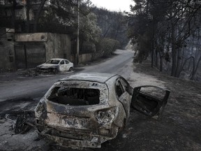 Burnt automobile shells line the streets following a wildfire at Neos Voutzas village, east of Athens, Greece, on July 25, 2018.