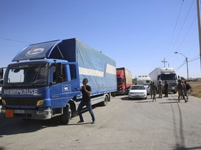 Trucks laden with aid for displaced Syrians wait to cross from Jordan to the Syrian side of the border, in Jabir As Sirhan, Jordan, Sunday, July 1, 2018. Jordan's prime minister visited the key crossing with Syria, inspecting aid deliveries by the Jordanian army to the tens of thousands of displaced Syrians gathering at the border Amman has chosen to keep sealed.