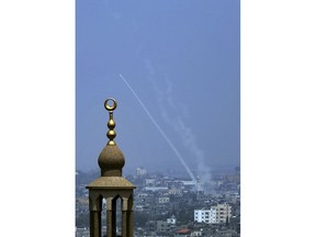 Smoke trails are seen as rockets are launched from the Gaza Strip towards Israel, in Gaza City, Saturday, July 14, 2018. The Israeli military carried out its largest daytime airstrike campaign in Gaza since the 2014 war Saturday as Hamas militants fired dozens of rockets into Israel, threatening to spark a wider conflagration after weeks of tensions along the volatile border.