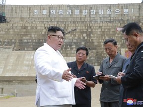 In this undated photo provided on Tuesday, July 17, 2018, by the North Korean government, North Korean leader Kim Jong Un, left, inspects the construction site of a hydroelectric power plant in North Hamgyong Province, North Korea. State media say that Kim has harshly reprimanded local officials over a delayed construction project. The slogan in the background reads: "March toward the final victory!" Independent journalists were not given access to cover the event depicted in this image distributed by the North Korean government. The content of this image is as provided and cannot be independently verified. Korean language watermark on image as provided by source reads: "KCNA" which is the abbreviation for Korean Central News Agency. (Korean Central News Agency/Korea News Service via AP)