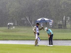 Matt Atkins, right, prepares to putt as caddie Christopher Schwertfeger holds an umbrella over him while finishing up the 9th hole, Sunday, July 22, 2018, in Nicholasville, Ky, during the final round of the PGA Tour Barbasol Championships at Keene Trace Golf Club.