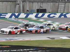 Cole Custer (00) leads the pack past the line at the start of a NASCAR Xfinity Series auto race at Kentucky Speedway, Friday, July 13, 2018, in Sparta, Ky.