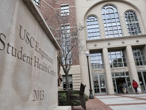 FILE - In this Tuesday, May 22, 2018, file photo, people enter the University of Southern California's Engemann Student Health Center in Los Angeles. More than 50 former and current students of the University of Southern California say in a new lawsuit that the school mishandled complaints that a longtime gynecologist engaged in inappropriate behavior during pelvic exams. The court filing Monday, July 23, 2018, by the firm D. Miller and Associates brings the number of people suing USC and Dr. George Tyndall to more than a hundred. Tyndall's denied wrongdoing and hasn't been charged with a crime but police are investigating dozens of allegations.