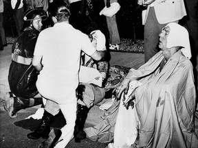 File - In this June 25, 1973 file photo, firemen give first aid to survivors of a French Quarter fire that swept through a second story bar leaving 29 dead and 15 injured in New Orleans. Several persons leaped to safety before the entire bar was engulfed in flames. A new book details the 1973 deadly fire at the gay bar that killed 32 patrons. Robert Fieseler's book is called "Tinderbox: The Untold Story of the Up Stairs Lounge Fire and the Rise of Gay Liberation."