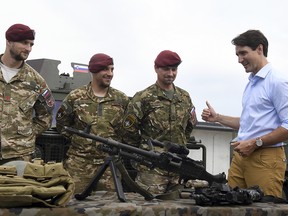 Canadian Prime Minister Justin Trudeau speaks to Slovenian soldiers as he inspects the troops while visiting Adazi Military Base in Kadaga, Latvia, on Tuesday, July 10, 2018.