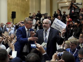 Security removes an apparent protester before a joint press conference between U.S. President Donald Trump and Russia President Vladimir Putin in the Presidential Palace in Helsinki, Finland, Monday, July 16, 2018.