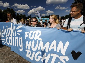 People take to Helsinki street, Sunday, July 15, 2018. Some 1,500 people are protesting in Helsinki to promote human and sexual rights, democracy and environmental issues ahead of Monday's summit in the Finnish capital between Donald Trump and Vladimir Putin.