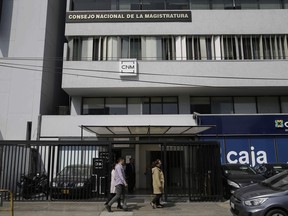 People pass Peru's National Judicial Council headquarters in Lima, Peru, Thursday, July 19, 2018. The head of Peru's judicial branch, Duberli Rodriguez, is offering his resignation over the latest corruption scandal to rock the South American nation, involving secretly recorded audio files released by a Peruvian website showing numerous judges willing to tender favors for friends.