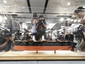 A scale model of the Russian warship Dmitrii Donskoi is surrounded by the media before a news conference in Seoul, South Korea, Thursday, July 26, 2018. A South Korean company is backing off its claim to have found the sunken Russian warship with an enormous cargo of gold.