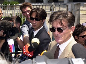 FILE - In this Wednesday June 27, 2001 file photo, Former Yugoslav President Slobodan Milosevic's lawyers Dragoslav Ognjanovic, center, and Zdenko Tomanovic, right, address media after the team visited imprisoned Milosevic in Belgrade. Serbian police say that a prominent lawyer, who helped defend former strongman Slobodan Milosevic before the Yugoslav war crimes tribunal, has been shot and killed. A police statement says that Dragoslav Ognjanovic was killed late on Saturday, July 28, 2018 outside his home the new part of Belgrade, the Serbian capital.