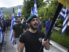 FILE - In this Sunday, June 17, 2018 file photo, opponents of the deal between Greece and Macedonia on the latter country's new name - North Macedonia - hold Greek flags as they protest at the village of Pisoderi, in northern Greece. Greece has moved to expel two Russian diplomats and to block two others from entering Thursday, July 12 over allegations that clergy and other organizations allegedly received Russian money to protest a deal to end Greece's longstanding name dispute with Macedonia.