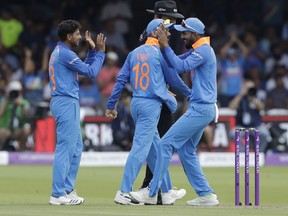 India's Kuldeep Yadav, left, celebrates taking the wicket of England captain Eoin Morgan during the one day cricket match between England and India at Lord's cricket ground in London, Saturday, July 14, 2018.