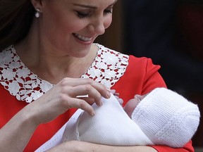 FILE - In this file photo dated Monday, April 23, 2018 Kate, Duchess of Cambridge holds her newborn baby son, to be named Prince Louis, as she leaves the Lindo wing at St Mary's Hospital in London London.  The Christening of Prince Louis, third child of the Duke and Duchess of Cambridge, will take place Monday July 9, 2018, at Chapel Royal in St. James's Palace, London.