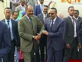 In this grab taken from video provided by ERITV, Ethiopia's Prime Minister Abiy Ahmed, centre right is welcomed by Erirea's President Isaias Afwerki as he disembarks the plane, in Asmara, Eritrea, Sunday, July 8, 2018.