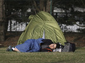 A person sleeps by their tent before joining the entrance queue in Wimbledon Park on day three at the Wimbledon Tennis Championships in London, Wednesday July 4, 2018.