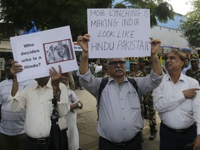 Indian activists hold placards during a protest against the recent attack on scholar and social activist Swami Agnivesh in Mumbai, India, Thursday, July 19, 2018. India's highest court on Tuesday asked the federal government to consider enacting a law to deal with an increase in mob violence and lynchings that have mostly followed rumors that the victims either belonged to members of child kidnapping gangs or were beef eaters and cow slaughterers.
